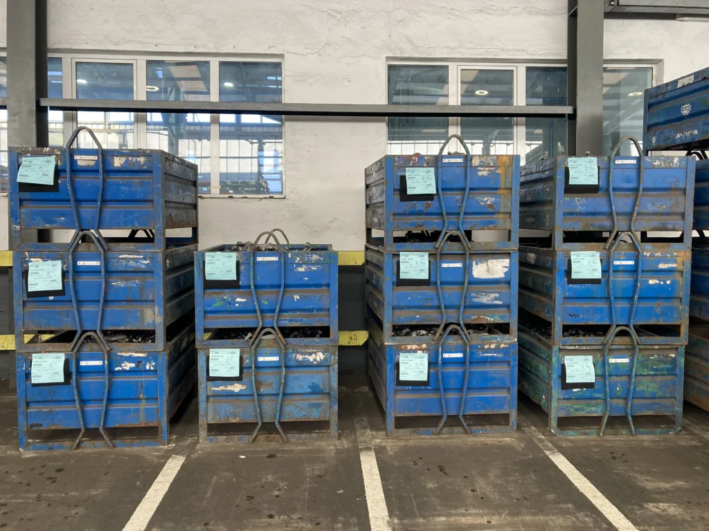 Contenedores industriales reutilizables azules en almacén, ejemplo real de gestión de envases bajo RD 1055/2022 y Reglamento UE 2025/40