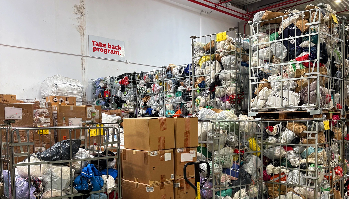 Planta de reciclaje textil con grandes vol&uacute;menes de residuo textil en proceso de clasificaci&oacute;n