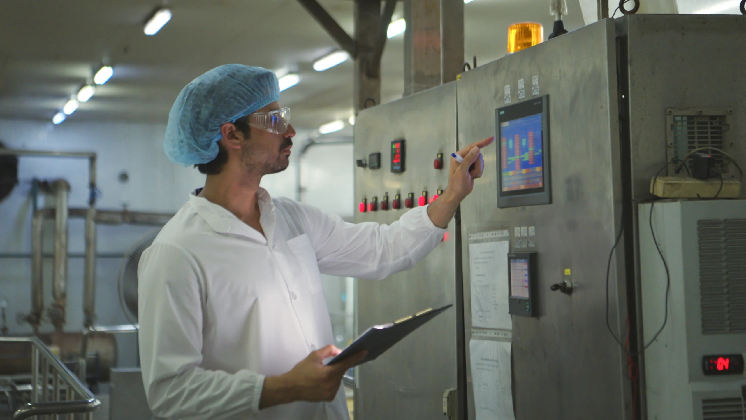 Operario revisando datos de control de calidad en una pantalla industrial